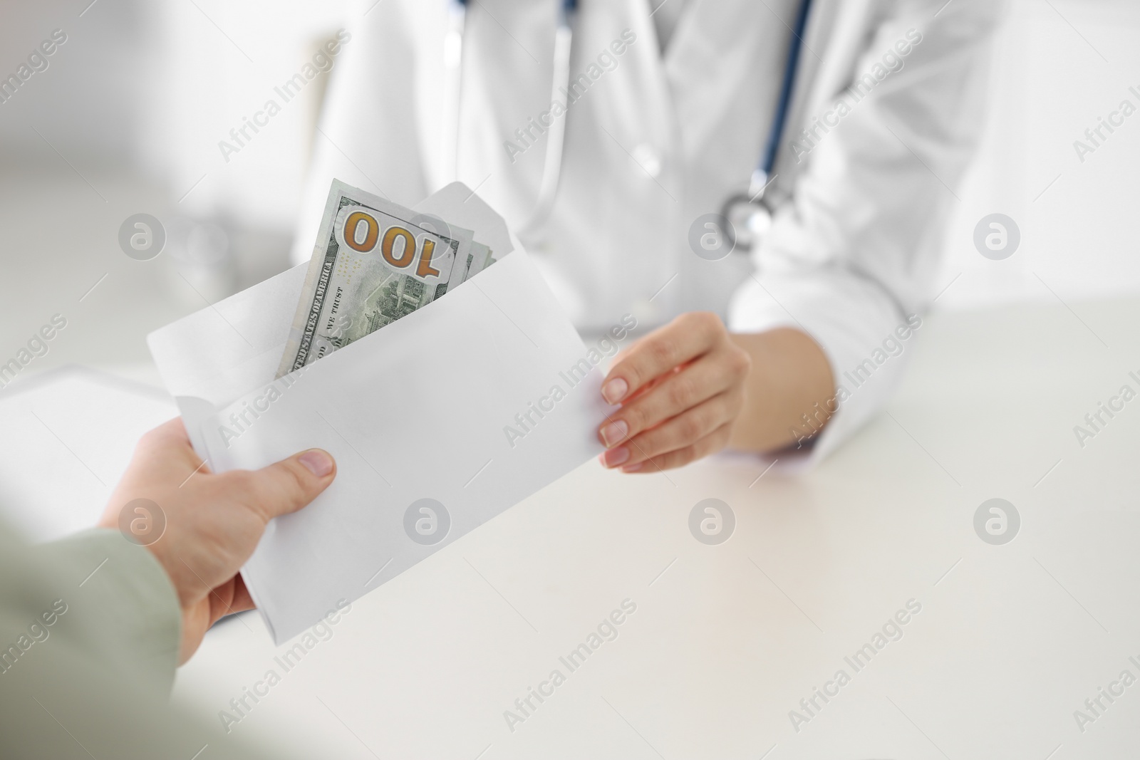 Photo of Patient giving bribe to doctor in clinic, closeup. Corrupted medicine