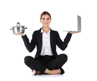 Photo of Businesswoman with saucepan and laptop sitting in lotus position on white background. Combining life and work