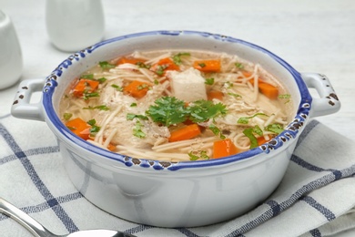 Photo of Dish with fresh homemade chicken soup served on table, closeup