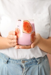 Photo of Woman holding fresh fig smoothie, closeup view