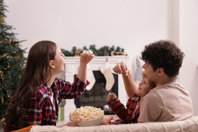 Photo of Family with popcorn spending time together at home. Watching movie via video projector