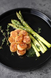 Photo of Delicious fried scallops with asparagus and thyme on grey table
