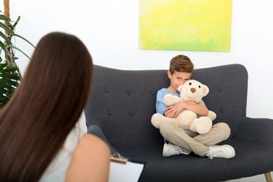 Child psychologist working with boy in office