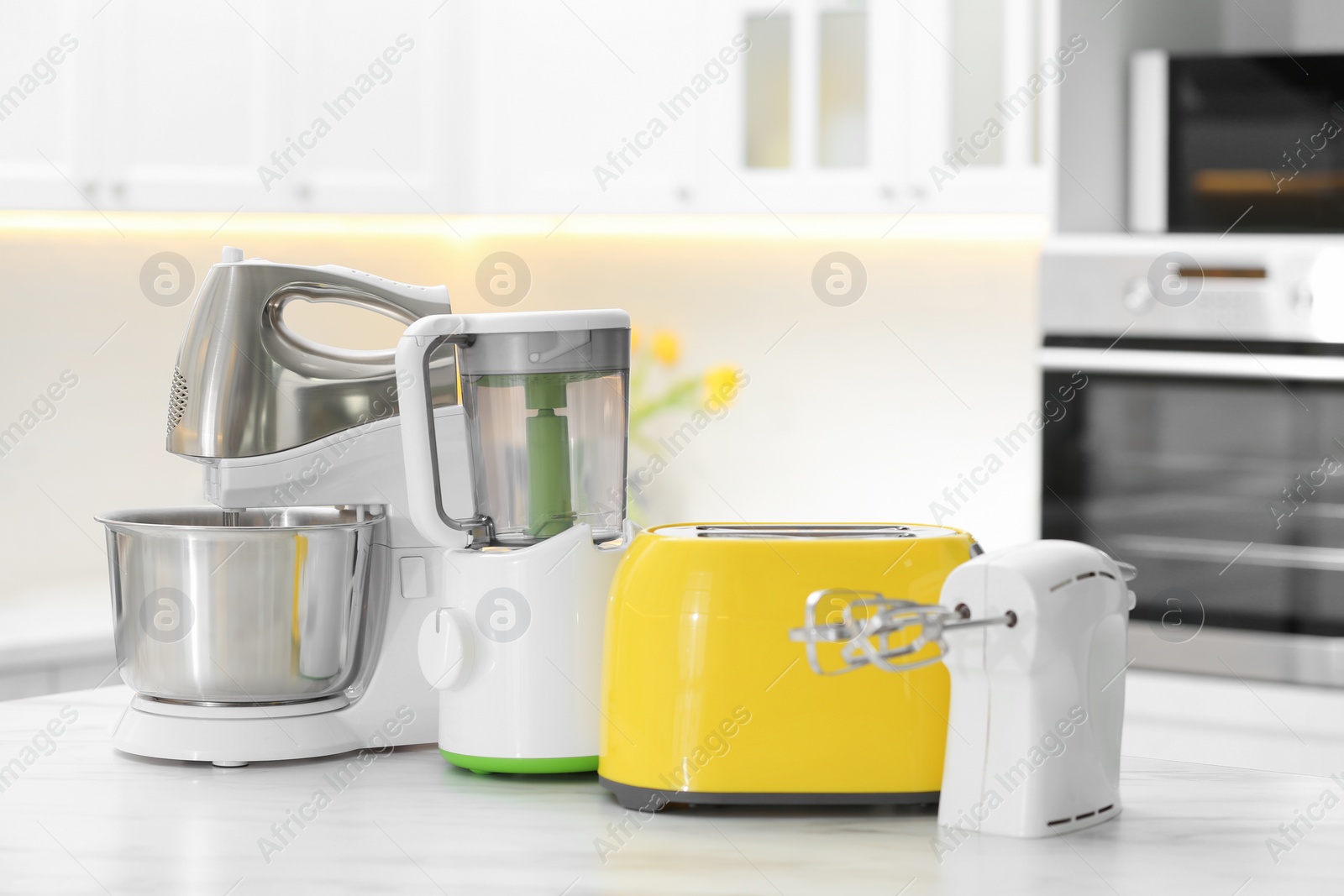 Photo of Modern toaster and other cooking appliances on table in kitchen