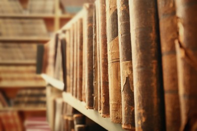 Image of Different old books on shelf in library, closeup