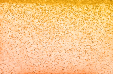 Image of Soda water with bubbles of gas, closeup. Toned in orange