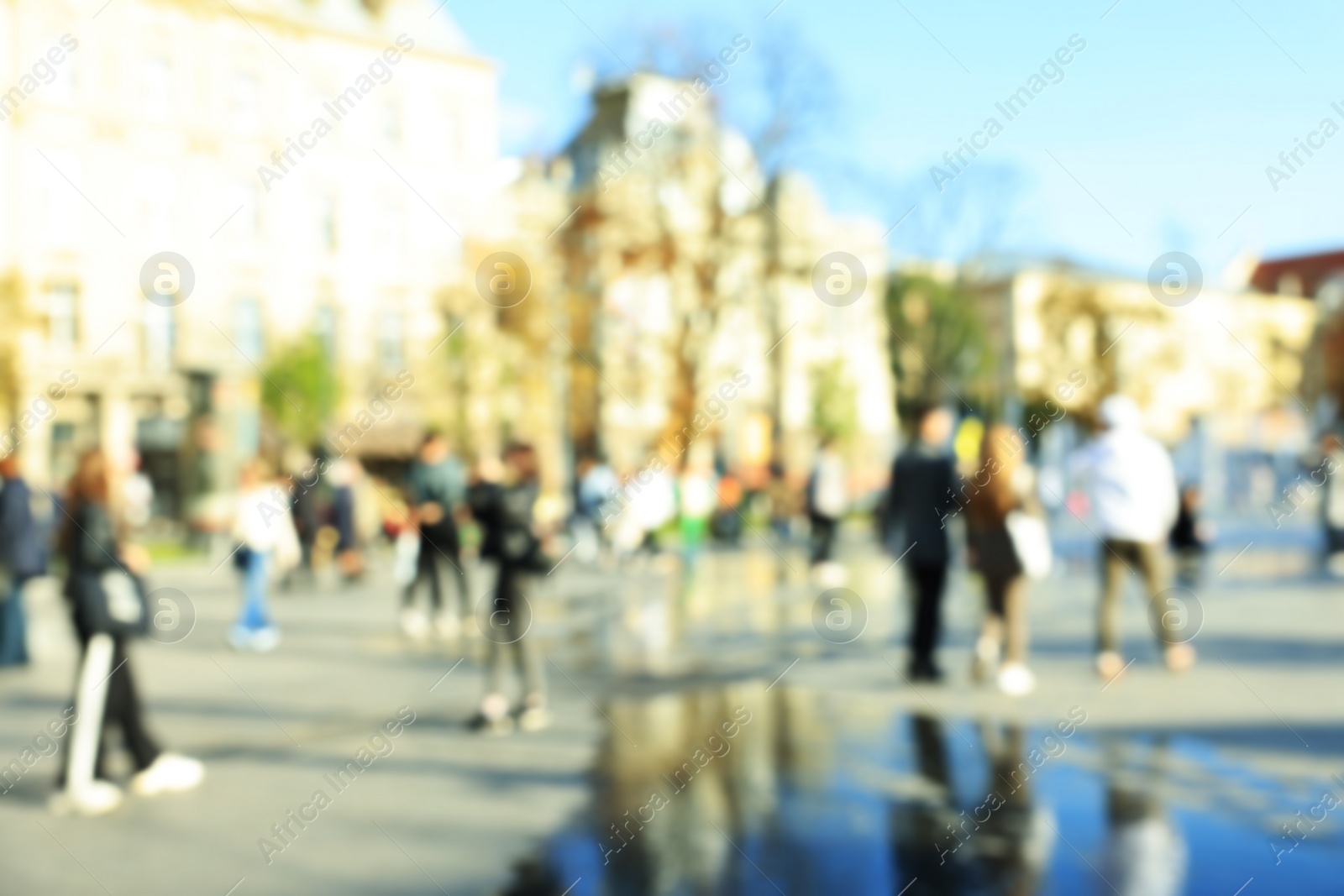 Photo of Blurred view of crowded street on sunny day. People walking in city