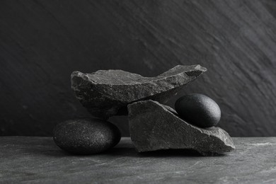 Photo of Presentation for product. Podium made of different stones on grey textured background