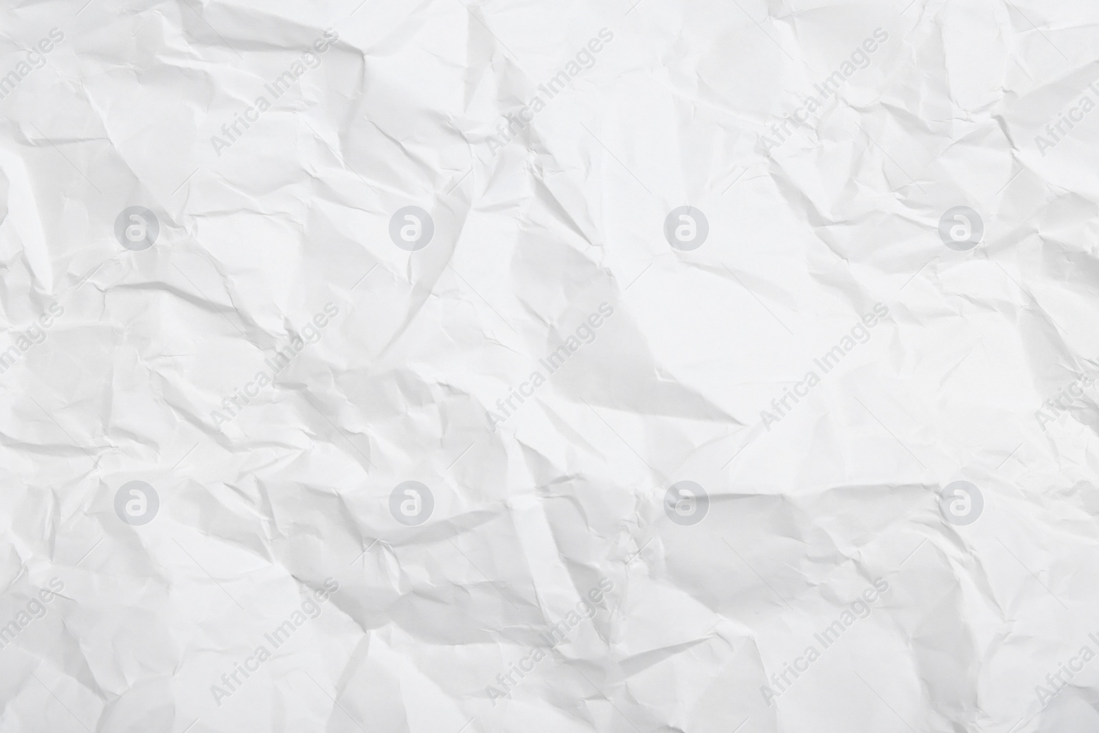 Photo of Sheet of white crumpled paper as background, closeup