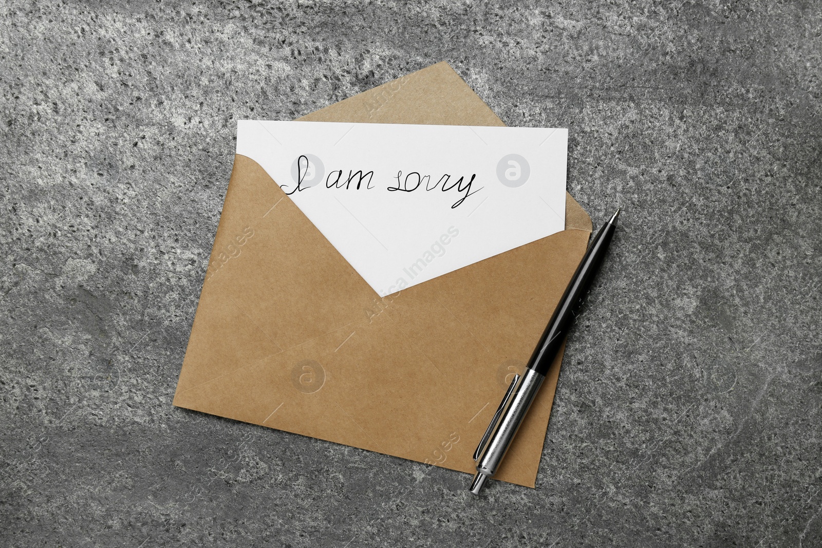 Image of Apology. Card with phrase I Am Sorry, envelope and pen on grey table, top view