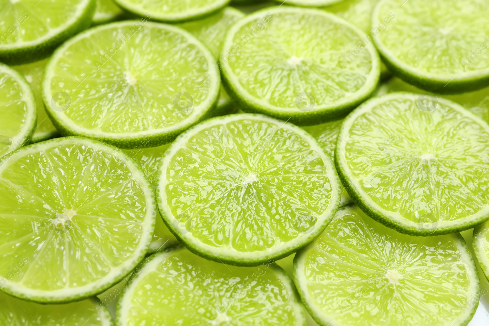 Photo of Fresh sliced ripe limes as background, closeup