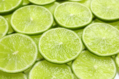 Photo of Fresh sliced ripe limes as background, closeup