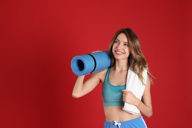 Photo of Beautiful woman with yoga mat and towel on red background. Space for text