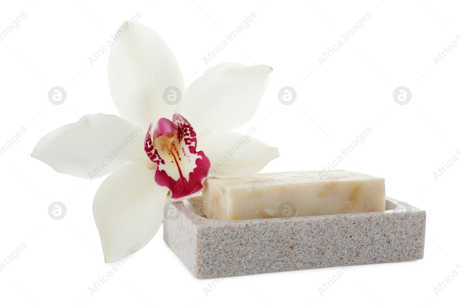 Photo of Dish with soap bar and beautiful lily on white table