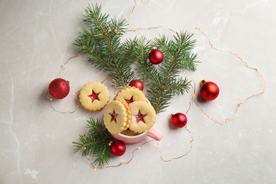 Photo of Traditional Linzer cookies with sweet jam and Christmas decorations on light background, top view