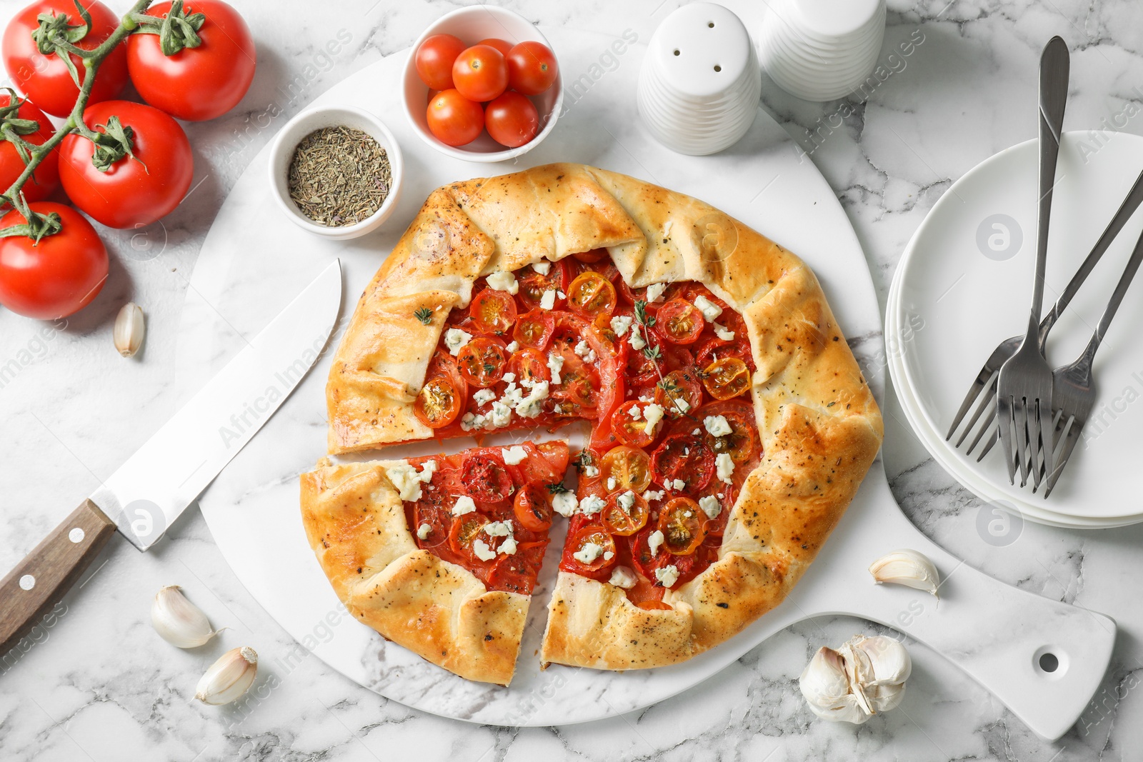 Photo of Flat lay composition of tasty galette with tomato, thyme and cheese (Caprese galette) on white marble table