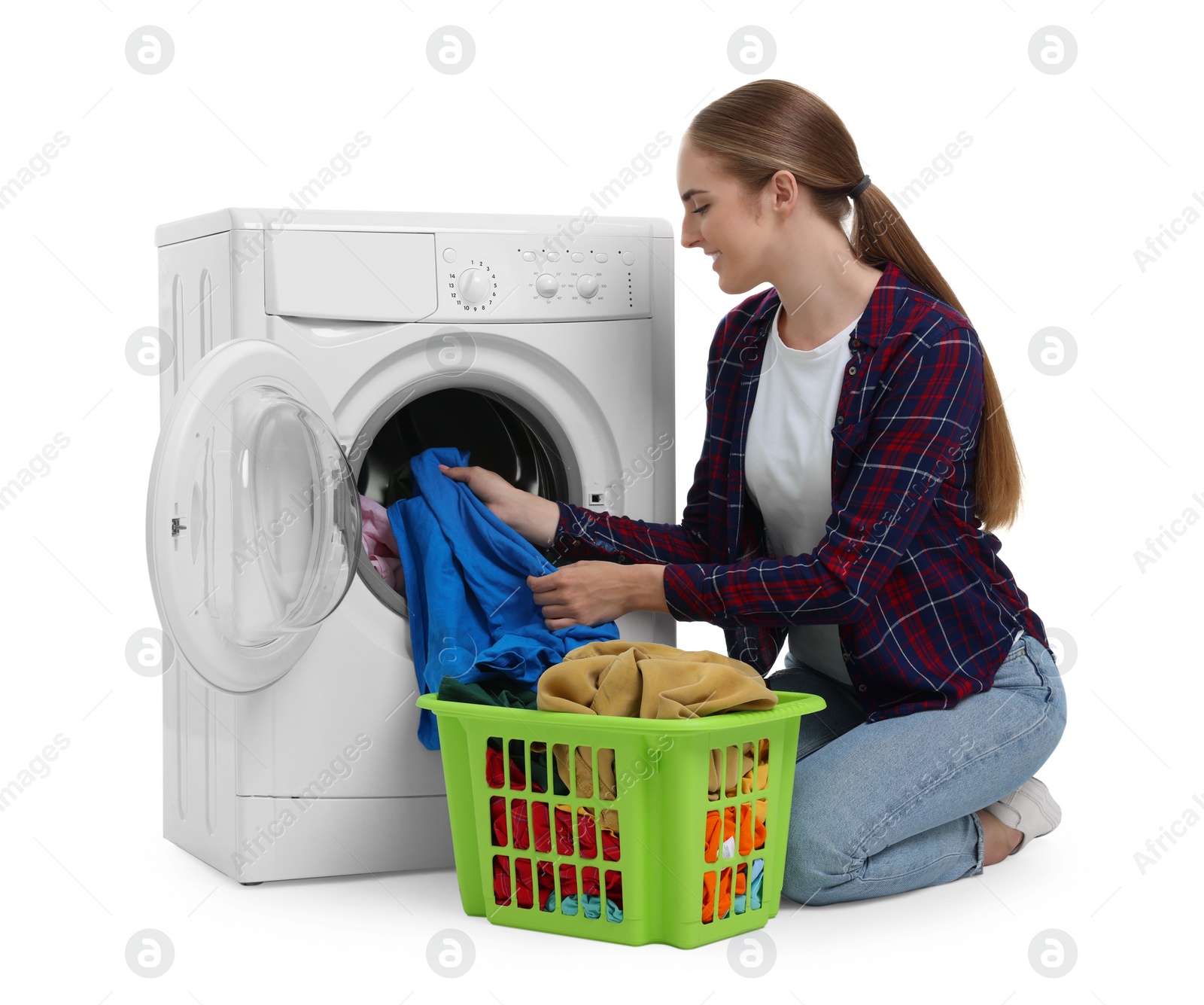 Photo of Beautiful young woman taking laundry out of washing machine on white background