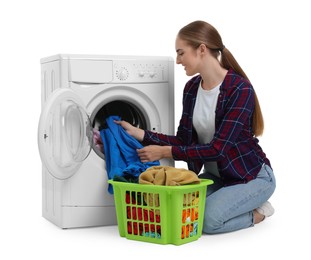 Photo of Beautiful young woman taking laundry out of washing machine on white background