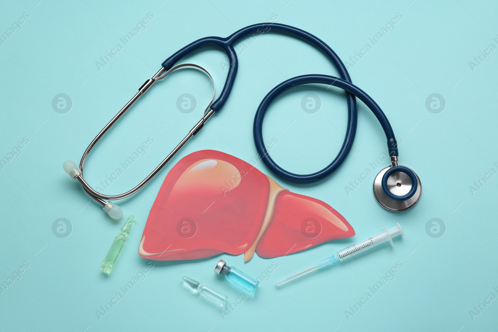 Photo of Paper liver, stethoscope, syringe and vials on turquoise background, flat lay. Hepatitis treatment