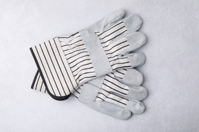 Pair of color gardening gloves on light grey table, top view