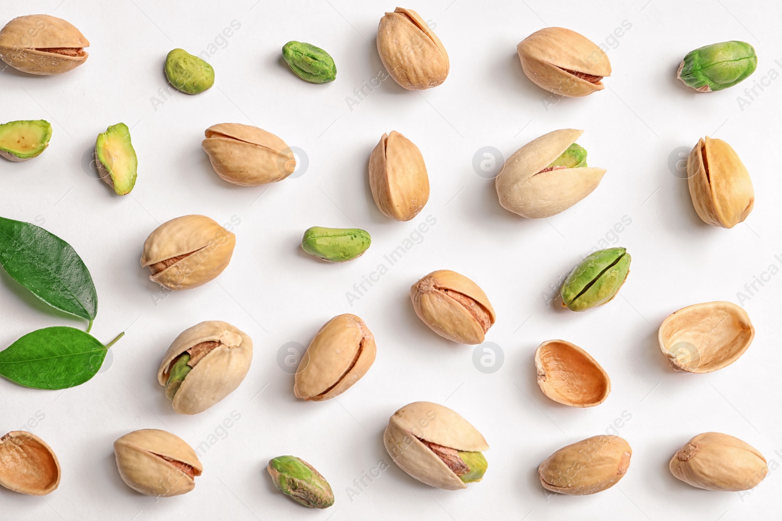 Photo of Organic pistachio nuts on white background, flat lay