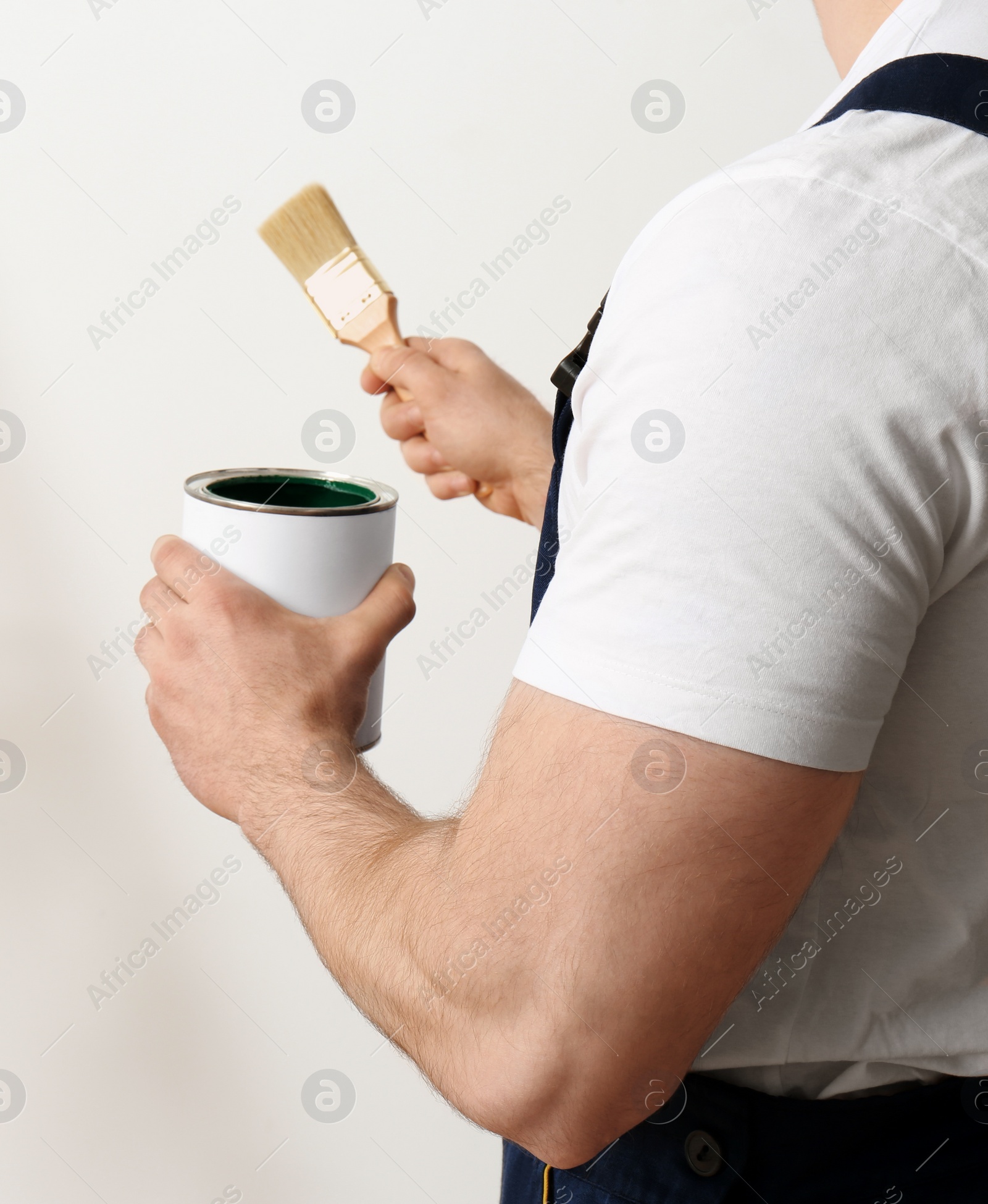 Photo of Male decorator with brush and paint can on white background, closeup