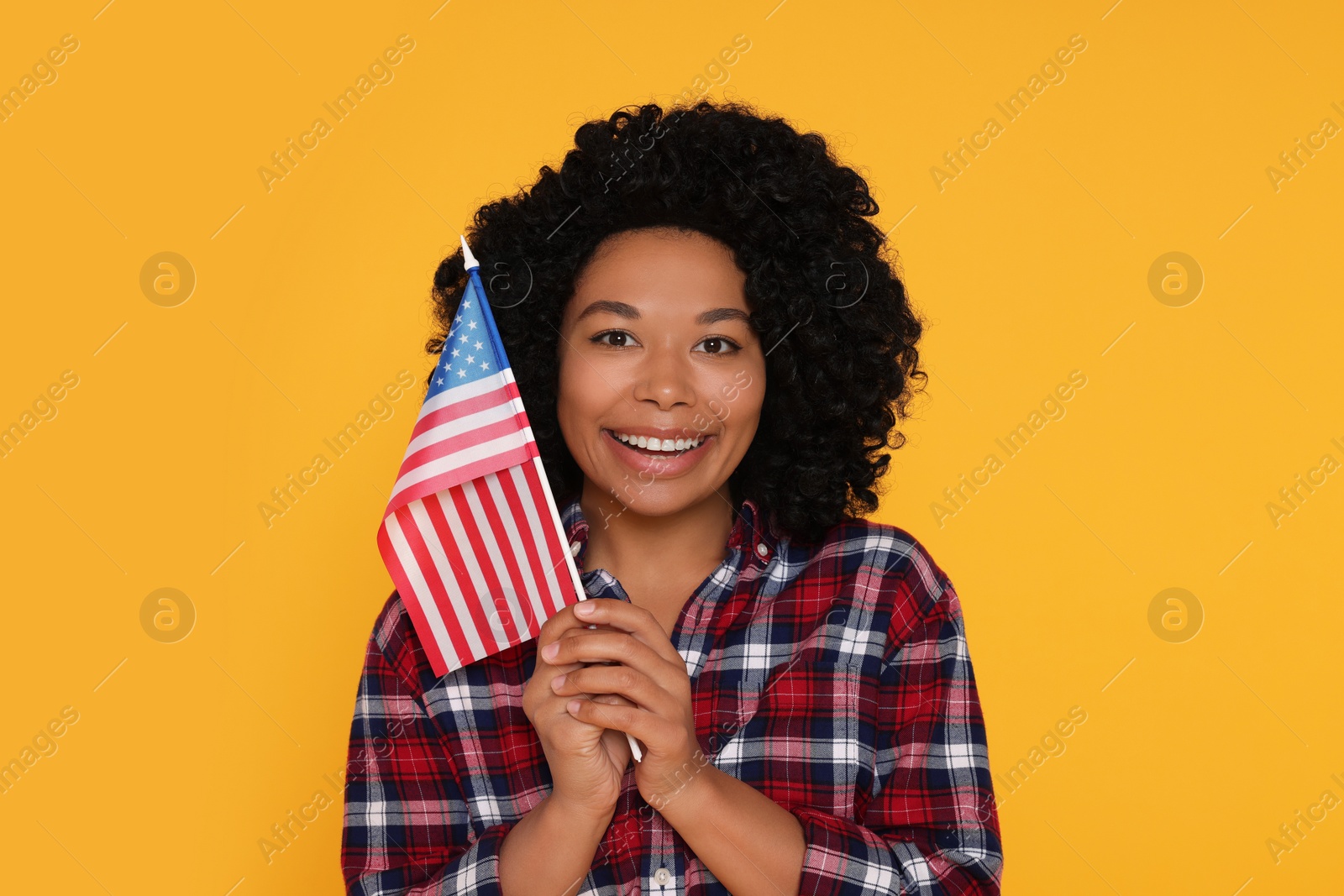 Photo of 4th of July - Independence Day of USA. Happy woman with American flag on yellow background