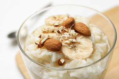 Photo of Delicious rice pudding with banana and almonds, closeup