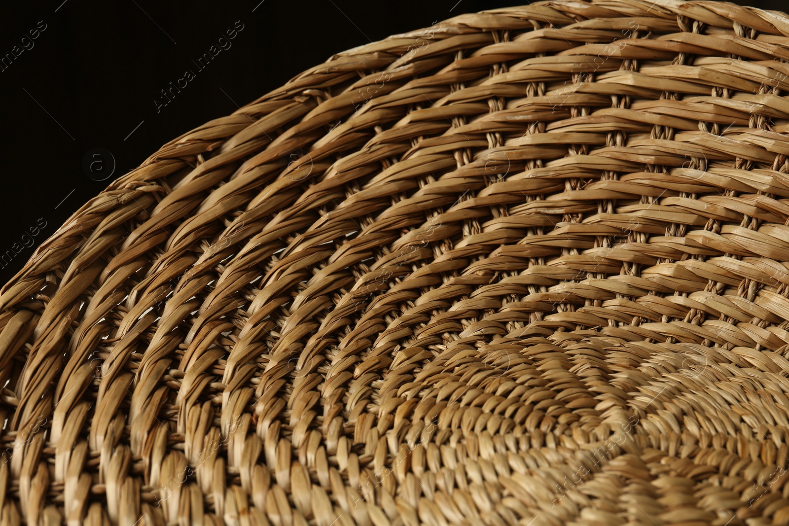 Photo of Empty wicker basket on black background, closeup