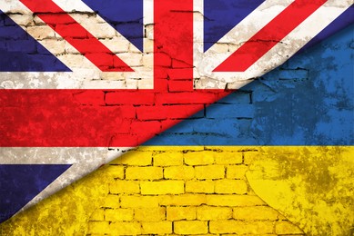 Image of Flags of United Kingdom and Ukraine on brick wall. International diplomatic relationships