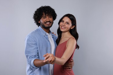 Photo of International dating. Happy couple dancing on light grey background