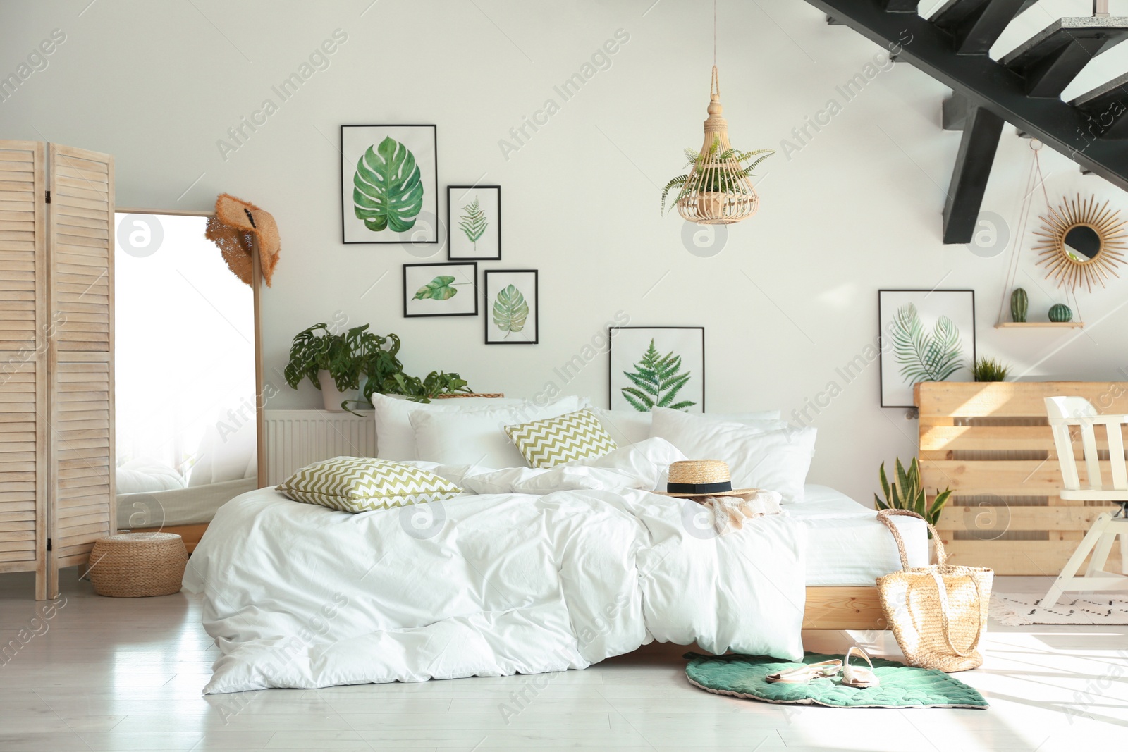 Photo of Stylish room interior with large comfortable bed under stairs