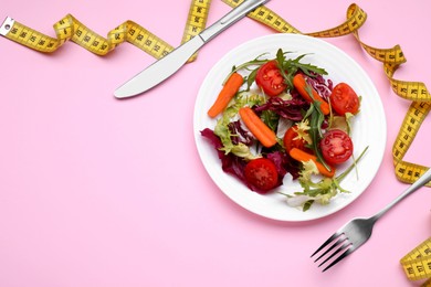 Photo of Healthy salad with measuring tape on pink background, flat lay and space for text. Diet concept