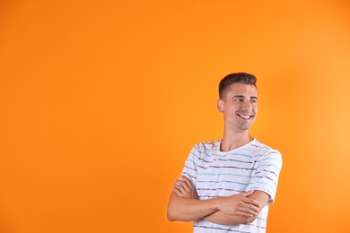 Handsome young man smiling on color background