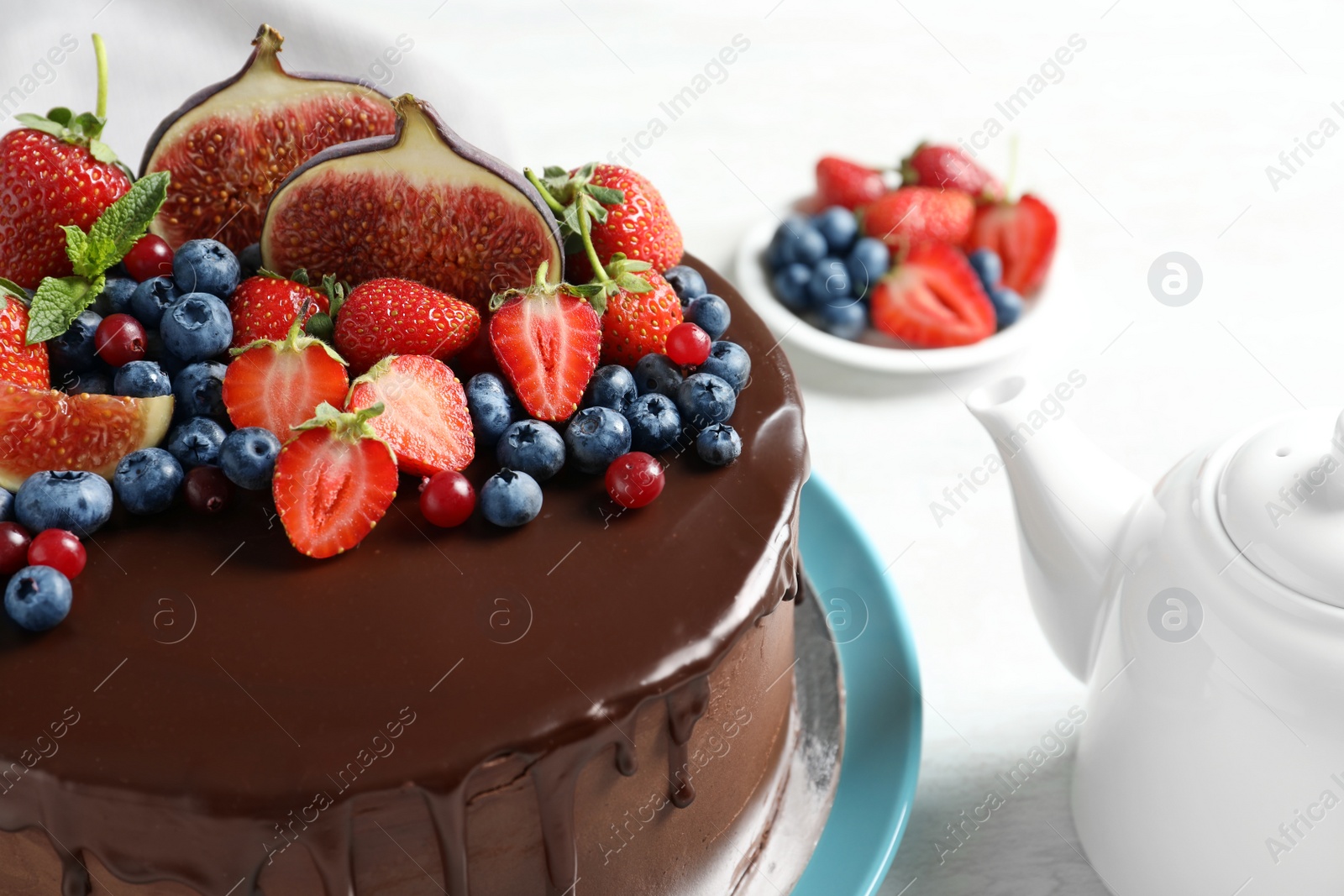 Photo of Fresh delicious homemade chocolate cake with berries on light table