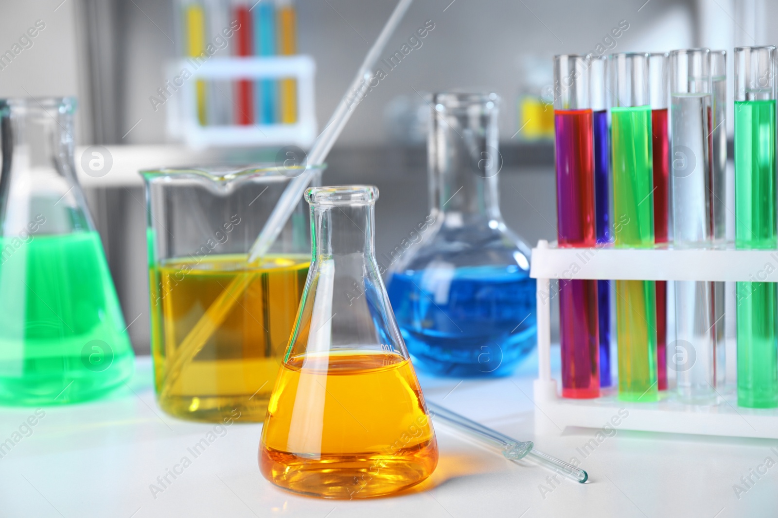 Photo of Different glassware with samples on table in chemistry laboratory