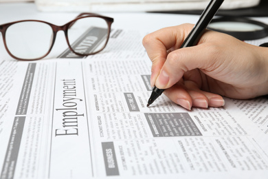 Woman marking advertisement in newspaper, closeup. Job search concept