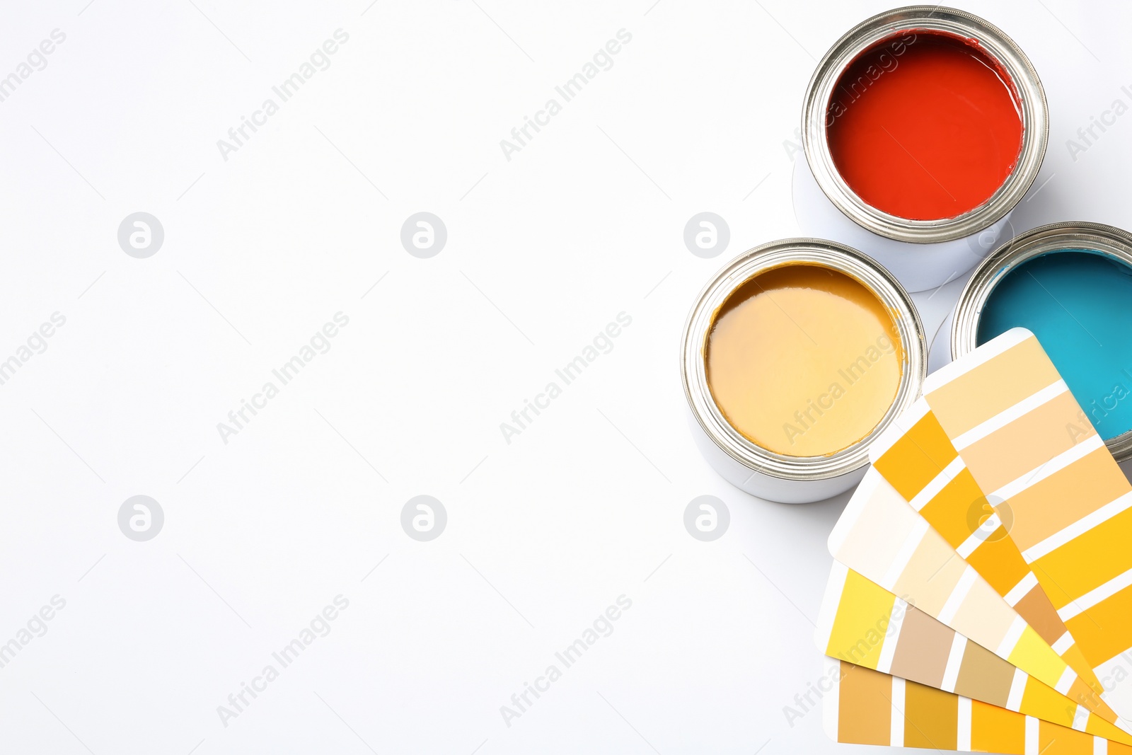 Photo of Paint cans and color palette on white background, top view. Space for text