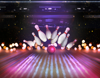 Image of Bowling ball bouncing pins, bokeh effect. Successful hit - strike