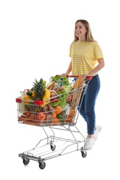 Photo of Young woman with shopping cart full of groceries on white background