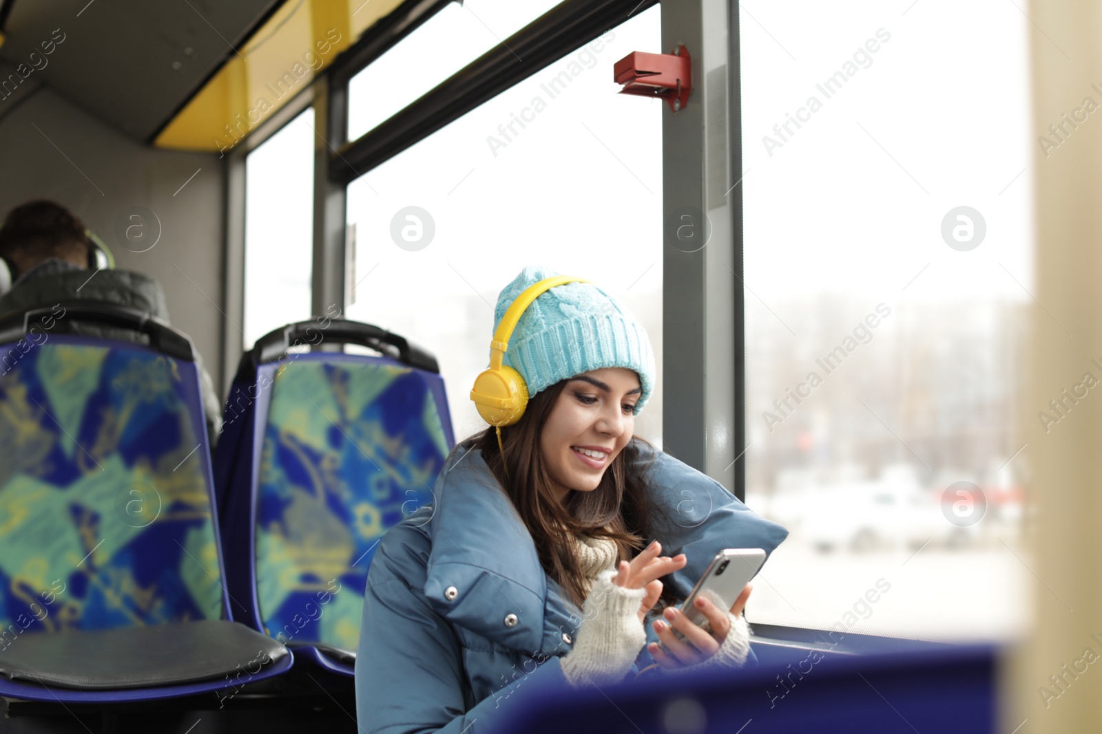 Photo of Young woman listening to music with headphones in public transport