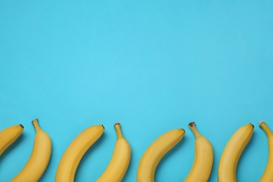 Ripe yellow bananas on turquoise background, flat lay. Space for text