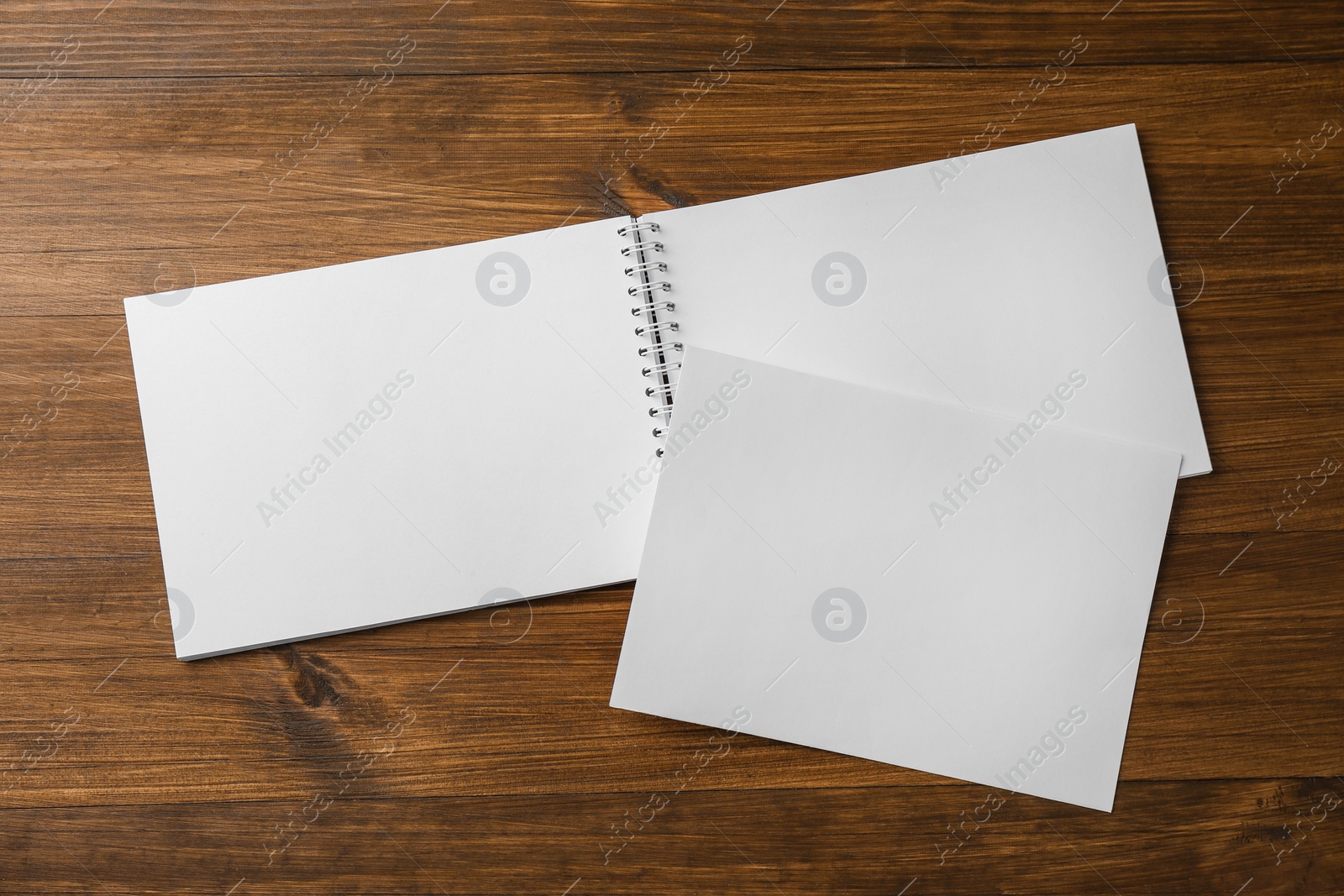 Photo of Sheet of paper and blank brochure on wooden table, flat lay. Mockup for design