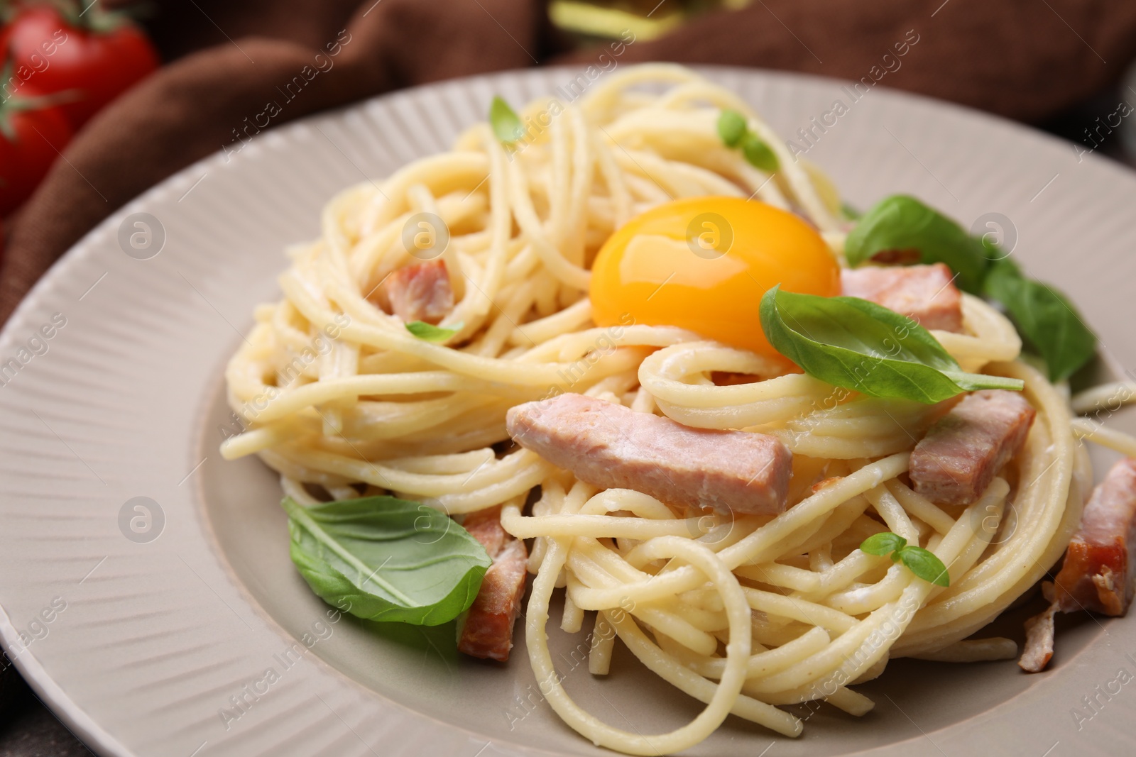 Photo of Delicious pasta Carbonara with egg yolk on plate, closeup