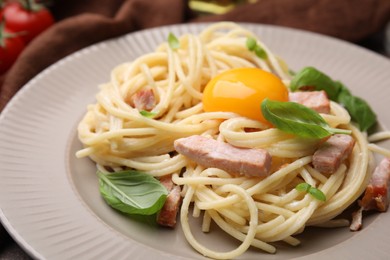 Delicious pasta Carbonara with egg yolk on plate, closeup