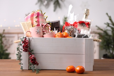 Photo of White crate with Christmas gift set on wooden table