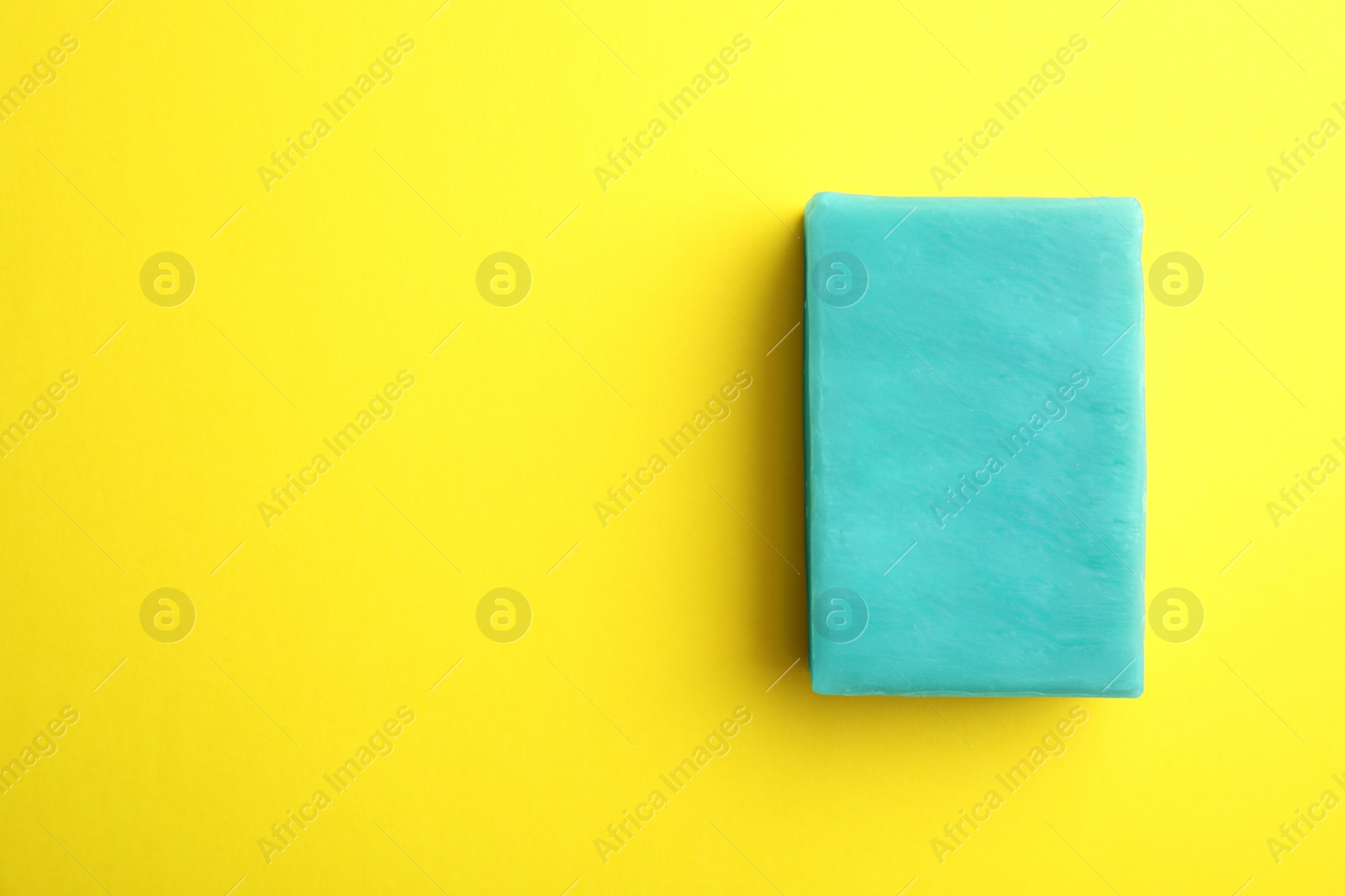 Photo of Soap bar and space for text on color background, top view