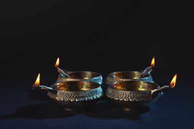 Photo of Diwali diyas or clay lamps on dark background