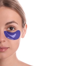 Beautiful young woman with blue under eye patch on white background