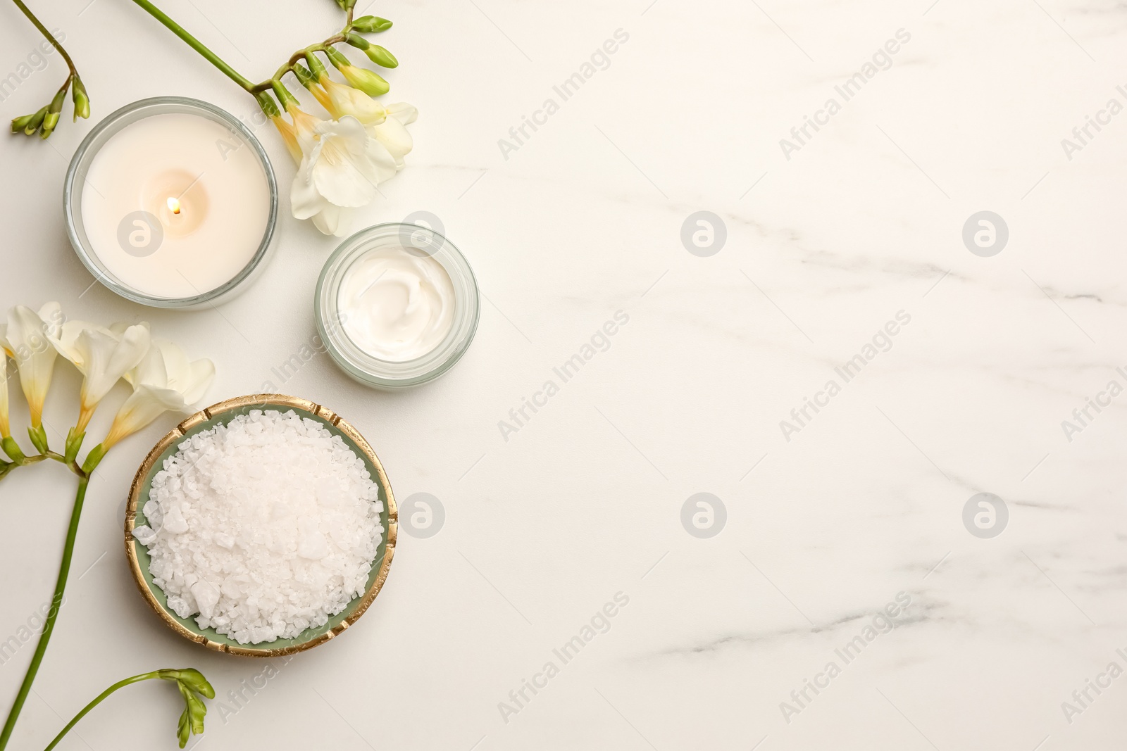 Photo of Flat lay composition with different spa products and flowers on white marble table. Space for text